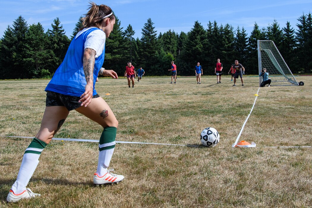 A woman takes a corner kick during a soccer game.