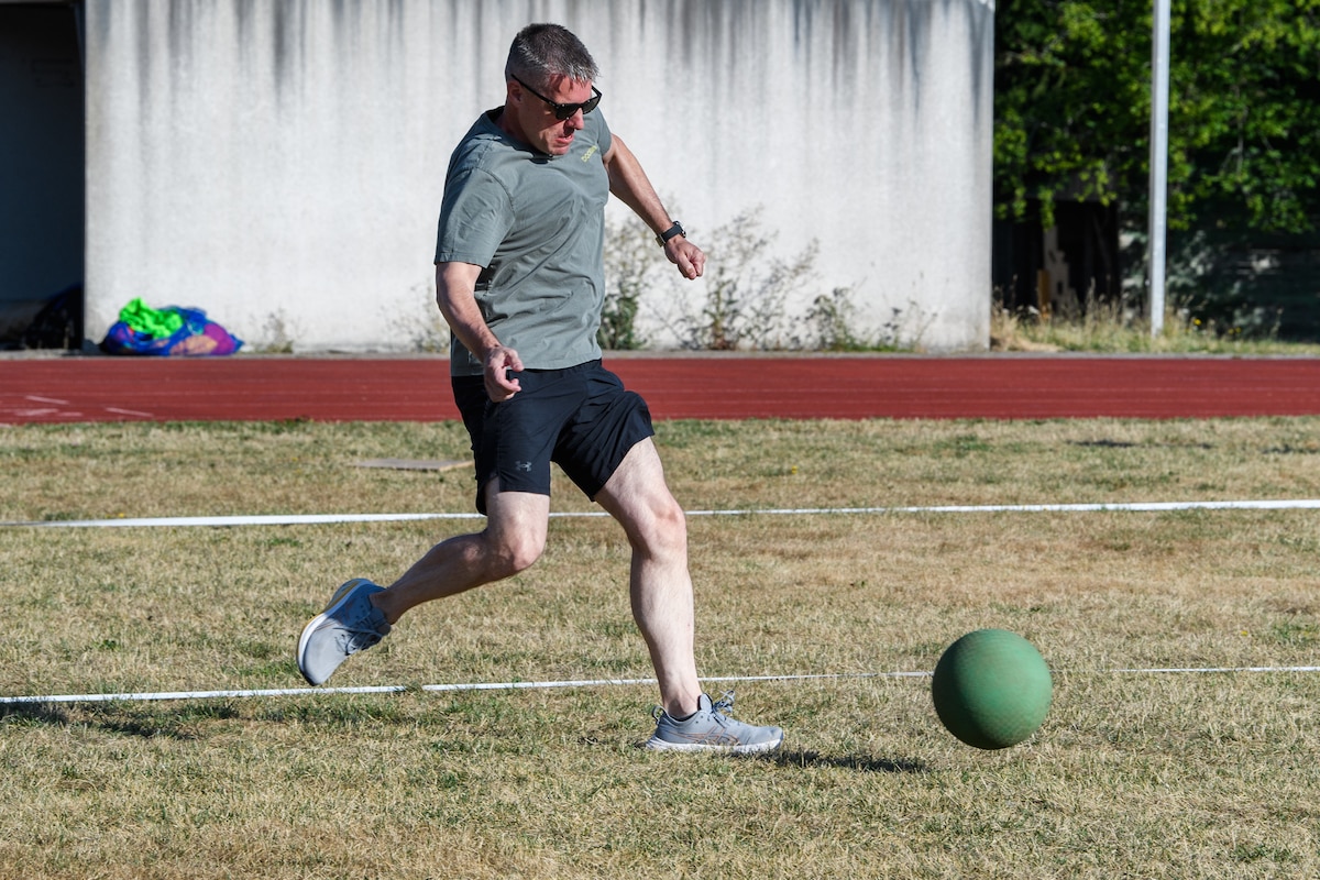 A man kicks a kickball