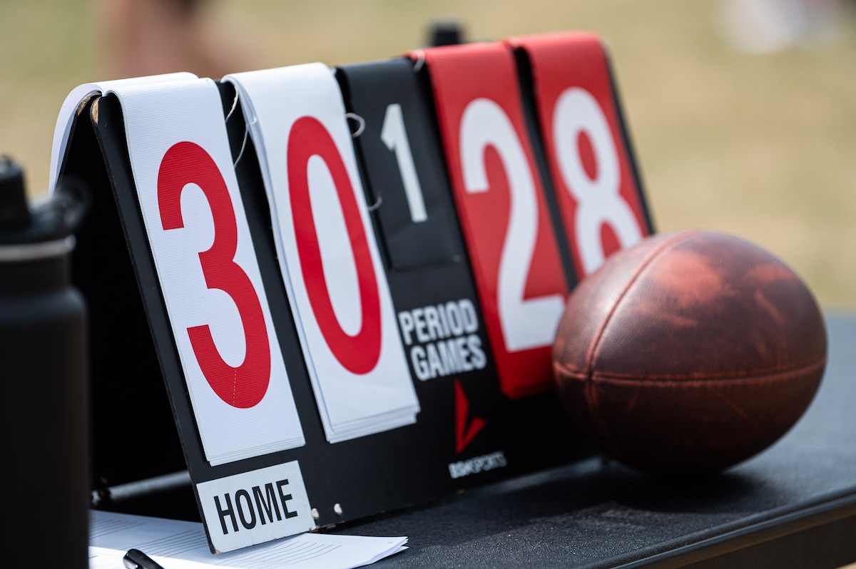 A scoreboard on a table reads 30-28 next to a football.