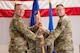 Men in uniform hold a flag.