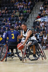 Retired U.S. Army Spc. Anthony Farve tries to maintain possession of the ball during the wheelchair basketball game against Team Navy at the 2025 Department of Defense Warrior Games at Colorado Springs, Colorado, July 20, 2025.