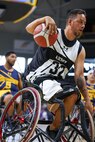 U.S. Army Retired Spc. Anthony Farve makes a move towards the basket at the wheelchair basketball game against Team Navy during the 2025 Department of Defense Warrior Games at Colorado Springs, Colorado, July 20, 2025.