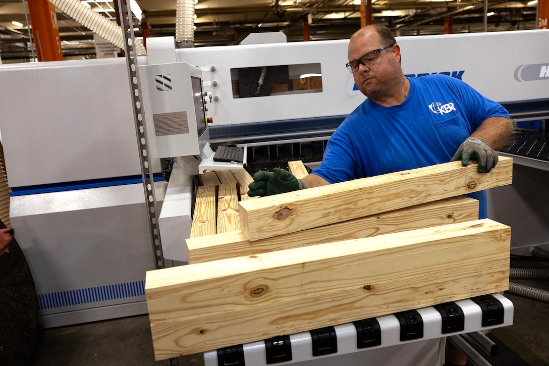 Jeremy Biggers, woodworker, operates a computer-controlled beam saw July 21, 2025, in the preservation, packing and packaging shop at Marine Corps Support Facility Blount Island in Florida. Installed for Blount Island Command, the HK5 PL Series Horizontal Beam Saw was placed into production that day to enhance precision cutting and output in support of global prepositioning missions. (Official Marine Corps Photo/Dustin Senger)