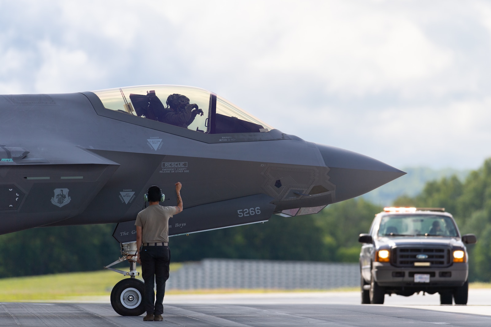 Photo of a U.S. Air National Guard crew chief assigned to the 158th Fighter Wing signals an F-35A Lightning II aircraft onto the flightline on South Bulington, VT, July 4, 2025.