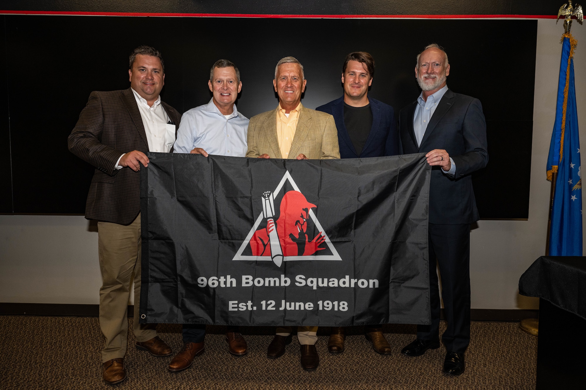 Members of Lt. Col. James Summersett’s family pose with the 96th Bomb Squadron flag