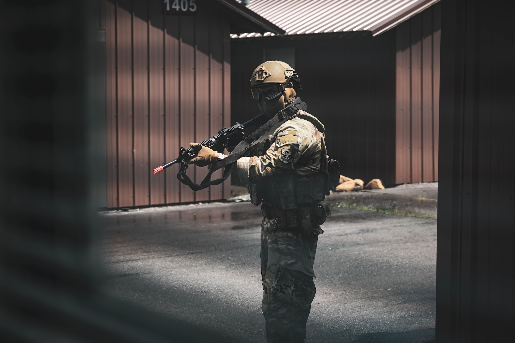 A man in uniform holds a weapon.