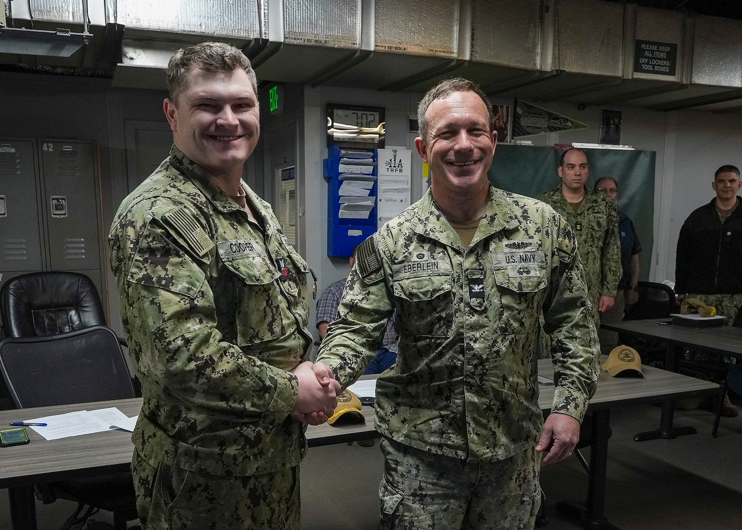Hull Maintenance Technician 1st Class Noah Cooper and Capt. Michael Eberlein, commanding officer, TRFB, pose for a photo at TRFB.