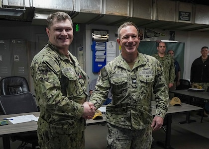 Hull Maintenance Technician 1st Class Noah Cooper and Capt. Michael Eberlein, commanding officer, TRFB, pose for a photo at TRFB.