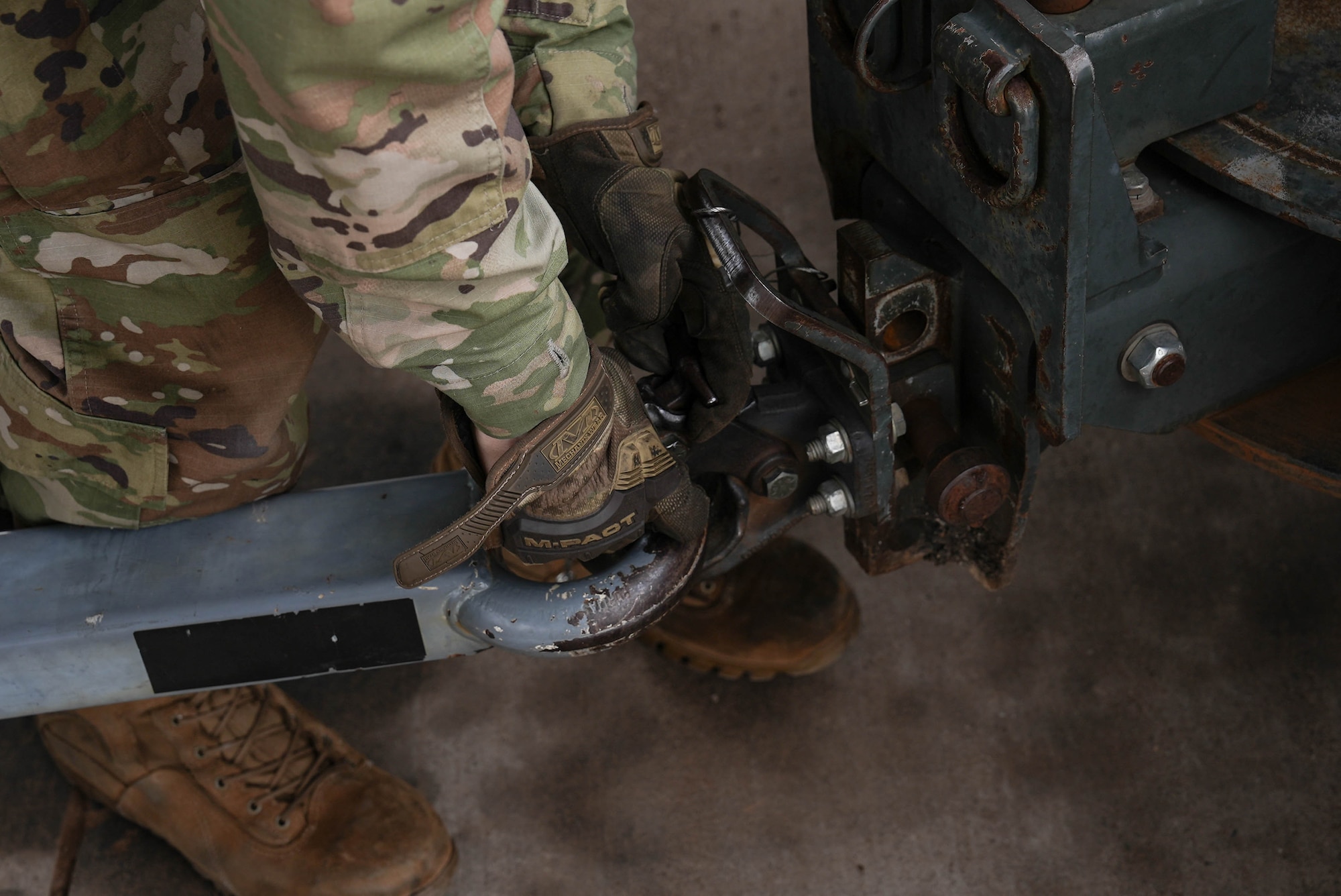 An Air Commando assigned to the 27th Special Operations Wing attaches a power cart to a pintle hook at Cannon Air Force Base, New Mexico, July 1, 2025. The aerospace ground equipment flight is responsible for the inspection and maintenance of a more than 900-asset equipment account, encompassing all the hardware that enables aircraft maintenance on the flightline. (U.S. Air Force photo by Staff Sgt. Kevin Williams)
