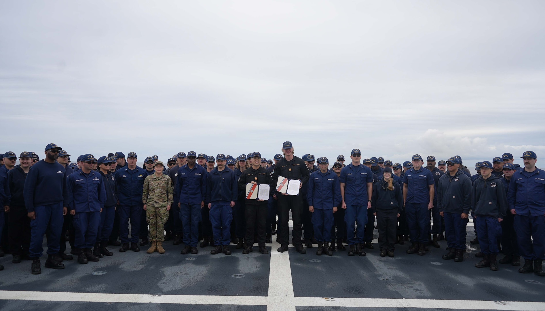 U.S. Coast Guard Cutter Munro (WMSL 755) formally recognizes crewmembers on the flight deck at the end of a 121-day deployment to the Bering Sea, Aleutian Islands and Arctic Circle July 10, 2025. Munro hosted two Royal Canadian Navy officers to expand opportunities for professional naval exchanges with U.S. allies and enhance key partnerships in the maritime Arctic region. (U.S. Coast Guard photo by Lt. j.g. Samika Lewis.)