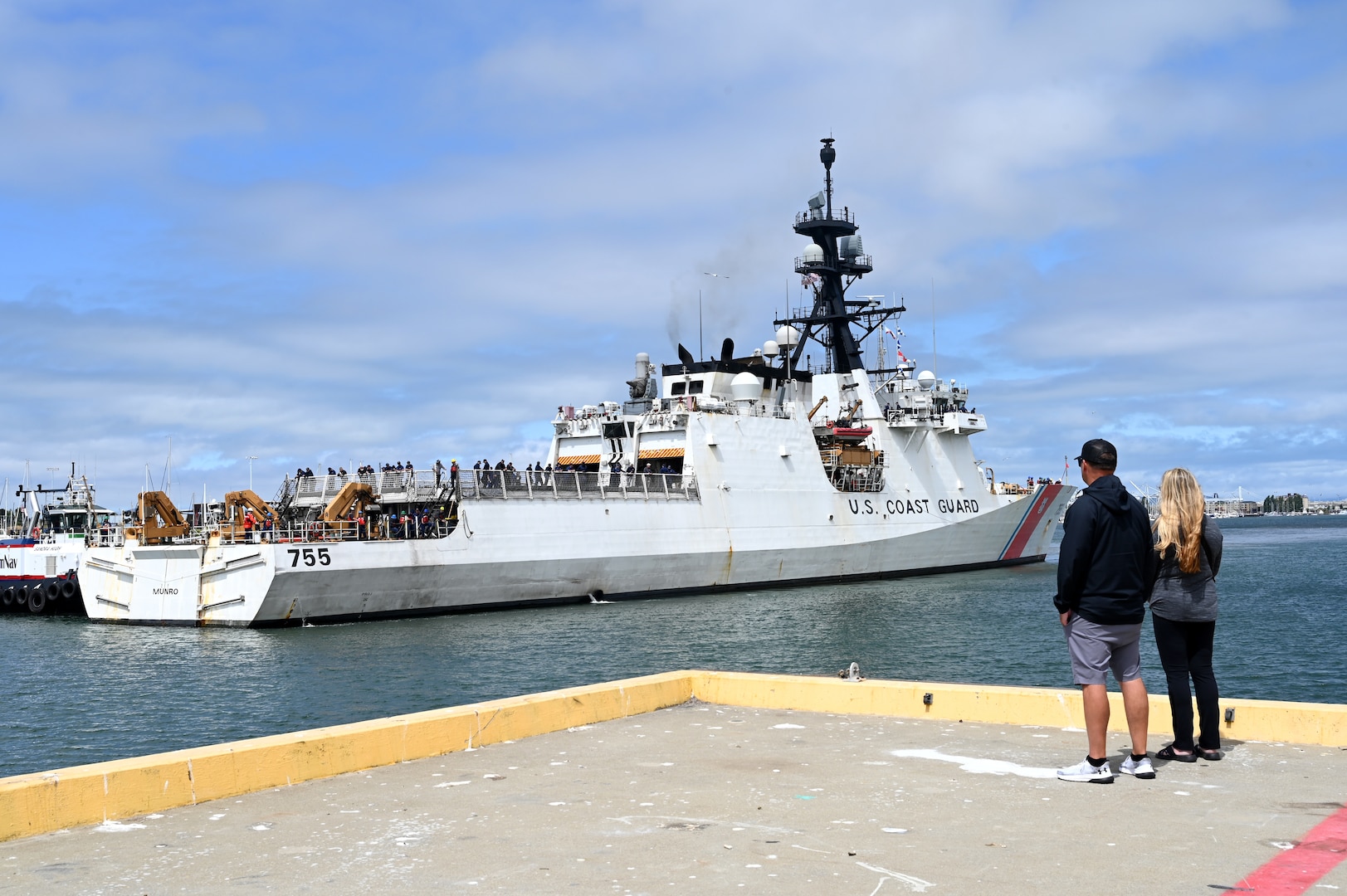 Friends and family members observe the U.S. Coast Guard Cutter Munro (WMSL 755) as it returns to home port in Alameda, California, July 16, 2025. The Munro returned to their home port following a 20,000-nautical-mile, 121-day deployment patrolling the Bering Sea. (U.S. Coast Guard photo by Petty Officer 3rd Class Joel LaVallee)