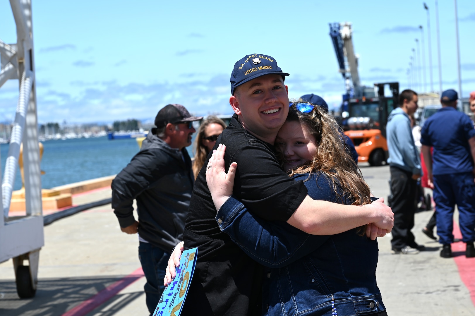 Friends and family members reunite with Coast Guard members stationed aboard the U.S. Coast Guard Cutter Munro (WMSL 755) as the cutter returns to home port in Alameda, California, July 16, 2025. The Munro returned to their home port following a 20,000-nautical-mile, 121-day deployment patrolling the Bering Sea. (U.S. Coast Guard photo by Petty Officer 3rd Class Joel LaVallee)