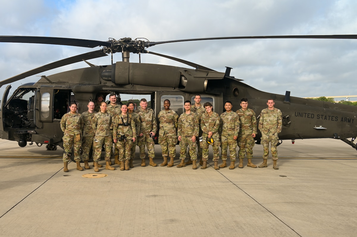 U.S. Air Force personnel from the 74th and 26th Aerial Port Squadron pose for a group photo beside a Texas Army National Guard UH-60 Black Hawk helicopter during Operation Dustoff Vigilance ’25, at Martindale Army Airfield, Texas, July 16, 2025.