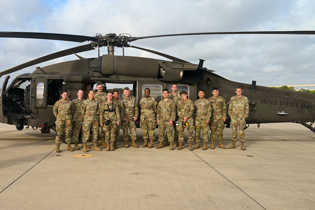 U.S. Air Force personnel from the 74th and 26th Aerial Port Squadron pose for a group photo beside a Texas Army National Guard UH-60 Black Hawk helicopter during Operation Dustoff Vigilance ’25, at Martindale Army Airfield, Texas, July 16, 2025.