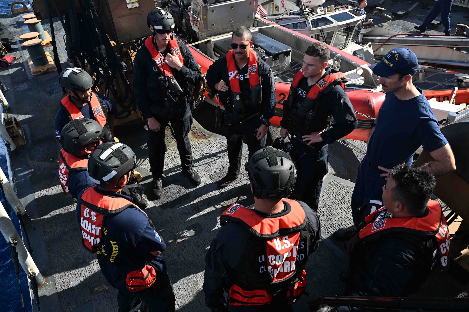 Officers from the Republic of the Marshall Islands (RMI) Sea Patrol and U.S. Coast Guard crew members assigned to the Legend-class U.S. Coast Guard Cutter Stratton (WMSL 752), conduct a debrief following a fisheries boarding within RMI’s exclusive economic zone, July 10, 2025. The U.S. Coast Guard and the RMI have long cooperated to enhance maritime security and sovereignty in the Pacific with a focus on bilateral maritime law enforcement operations that help combat maritime trafficking and safeguard fisheries for both countries. (U.S. Coast Guard photo by Petty Officer 2nd Class Kate Kilroy)