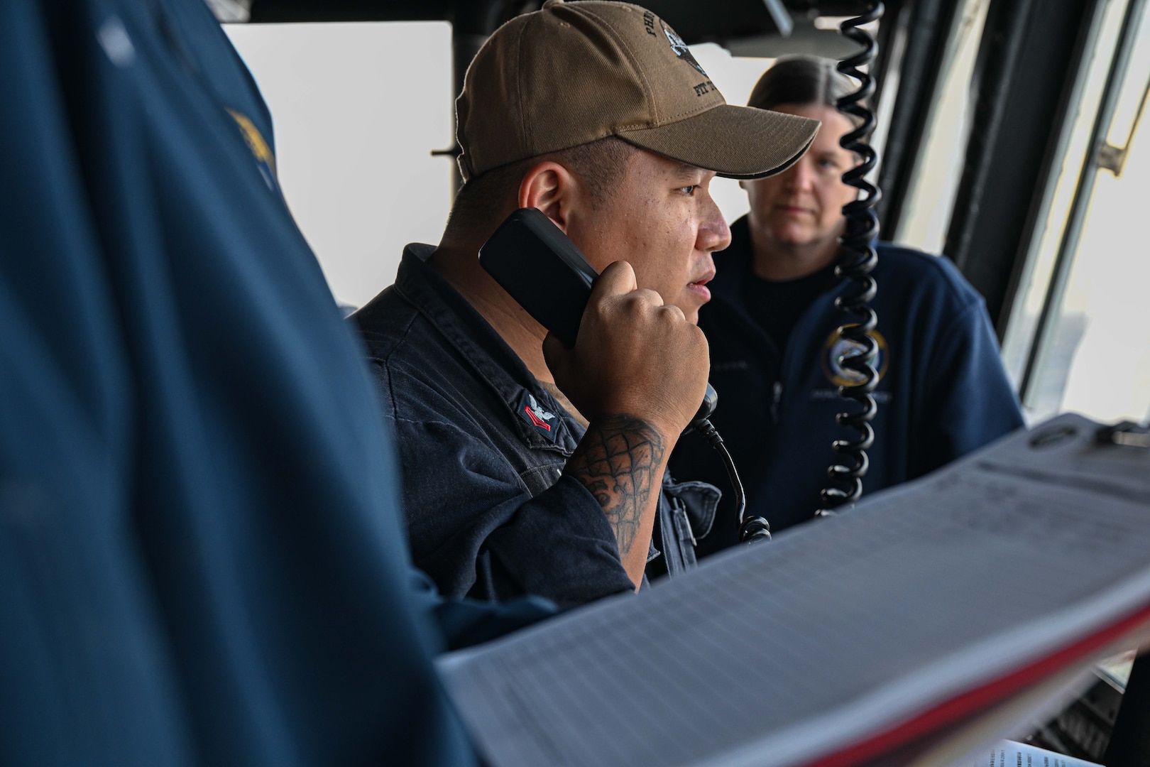 U.S. Navy Petty Officer 1st Class Yiyang Liu, a crew member temporarily assigned to the Legend-class U.S. Coast Guard Cutter Stratton (WMSL 752), queries a fishing vessel crew  within the Republic of the Marshall Islands (RMI) exclusive economic zone, July 10, 2025. The U.S. Coast Guard and the RMI have long cooperated to enhance maritime security and sovereignty in the Pacific with a focus on bilateral maritime law enforcement operations that help combat maritime trafficking and safeguard fisheries for both countries. (U.S. Coast Guard photo by Petty Officer 2nd Class Kate Kilroy)
