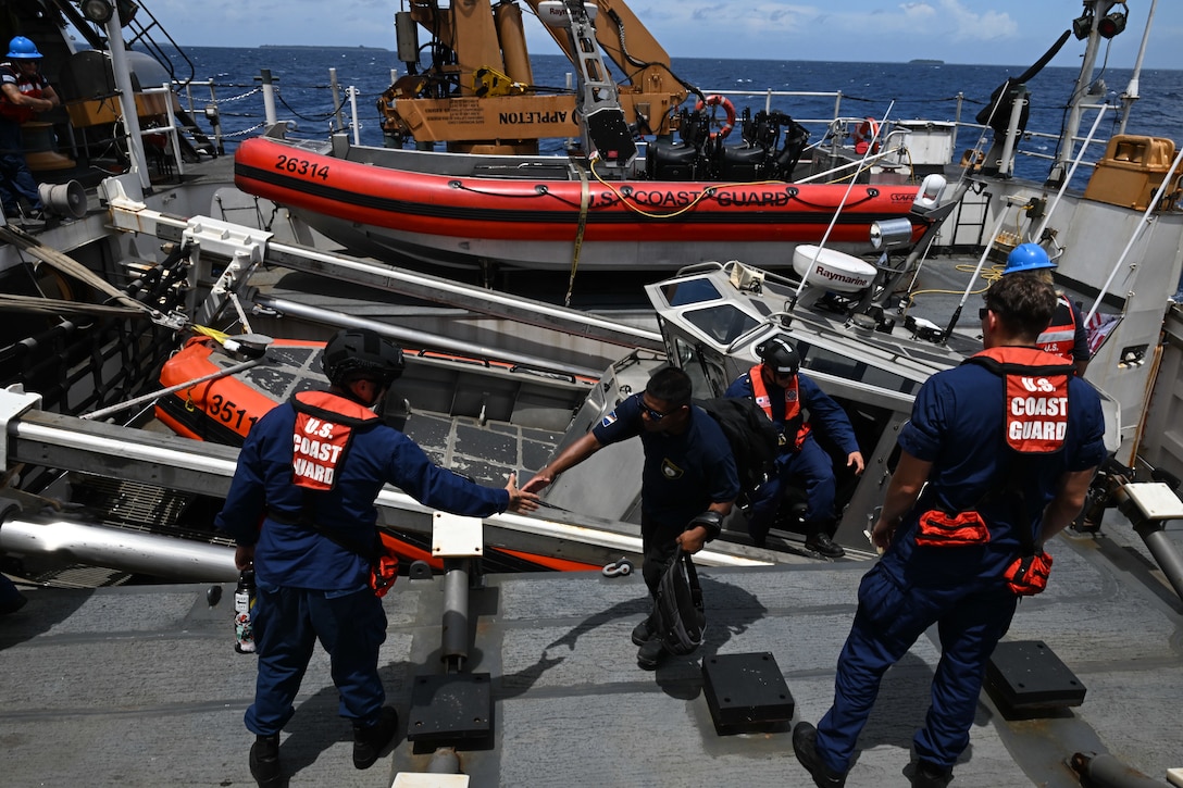 Crew members from the Legend-class U.S. Coast Guard Cutter Stratton (WMSL 752) bring Republic of the Marshall Islands (RMI) Sea Patrol Able Seaman aboard Stratton for bilateral maritime law enforcement operations in RMI waters, July 9, 2025. The U.S. Coast Guard and the RMI have long cooperated to enhance maritime security and sovereignty in the Pacific with a focus on bilateral maritime law enforcement operations that help combat maritime trafficking and safeguard fisheries for both countries. (U.S. Coast Guard photo by Petty Officer 2nd Class Kate Kilroy)