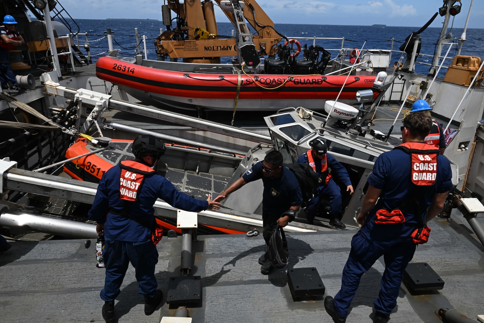 Crew members from the Legend-class U.S. Coast Guard Cutter Stratton (WMSL 752) bring Republic of the Marshall Islands (RMI) Sea Patrol Able Seaman aboard Stratton for bilateral maritime law enforcement operations in RMI waters, July 9, 2025. The U.S. Coast Guard and the RMI have long cooperated to enhance maritime security and sovereignty in the Pacific with a focus on bilateral maritime law enforcement operations that help combat maritime trafficking and safeguard fisheries for both countries. (U.S. Coast Guard photo by Petty Officer 2nd Class Kate Kilroy)
