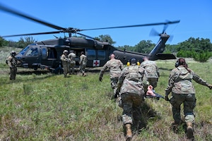 U.S. Air Force personnel from the 74th and 26th Aerial Port Squadron work with Texas Army National Guard members to practice medevac procedures alongside a UH-60 Black Hawk helicopter during OPERATION DUSTOFF VIGILANCE ’25, at Joint Base San Antonio-Camp Bullis, Texas, July 16, 2025.