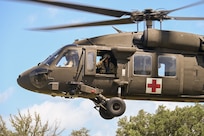 Texas Army National Guard Lt. Col. Christopher Stephens, UH-60 flight surgeon with Charlie Company, 2nd General Support Aviation Battalion, 36th Combat Aviation Brigade, salutes U.S. Air Force personnel and others during takeoff at OPERATION DUSTOFF VIGILANCE ’25 at Joint Base San Antonio-Camp Bullis, Texas, July 16, 2025.