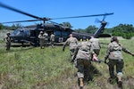 U.S. Air Force personnel from the 74th and 26th Aerial Port Squadron work with Texas Army National Guard members to practice medevac procedures alongside a UH-60 Black Hawk helicopter during OPERATION DUSTOFF VIGILANCE ’25, at Joint Base San Antonio-Camp Bullis, Texas, July 16, 2025.