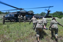 U.S. Air Force personnel from the 74th and 26th Aerial Port Squadron work with Texas Army National Guard members to practice medevac procedures alongside a UH-60 Black Hawk helicopter during OPERATION DUSTOFF VIGILANCE ’25, at Joint Base San Antonio-Camp Bullis, Texas, July 16, 2025.