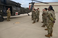 Texas Army National Guard Staff Sgt. Joseph Zabbatino, an instructor with the combat medic training program, 232nd Medical Battalion, 32nd Medical Brigade, Medical Center of Excellence, briefs U.S. Air Force personnel from the 74th and 26th Aerial Port Squadron in preparation to board a UH-60 Black Hawk helicopter for OPERATION DUSTOFF VIGILANCE ’25, at Martindale Army Airfield, Texas, July 16, 2025.