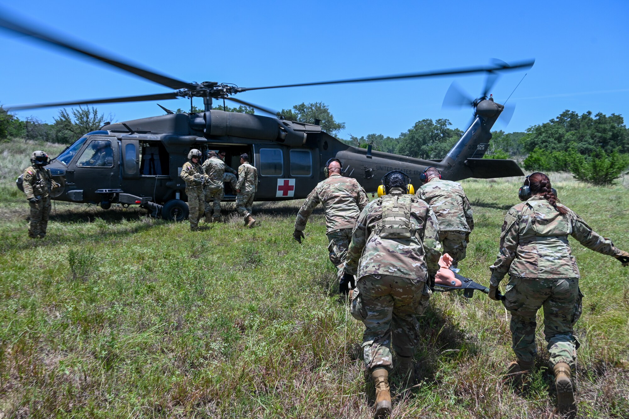 U.S. Air Force personnel from the 74th and 26th Aerial Port Squadron work with Texas Army National Guard members to practice medevac procedures alongside a UH-60 Black Hawk helicopter during OPERATION DUSTOFF VIGILANCE ’25, at Joint Base San Antonio-Camp Bullis, Texas, July 16, 2025.