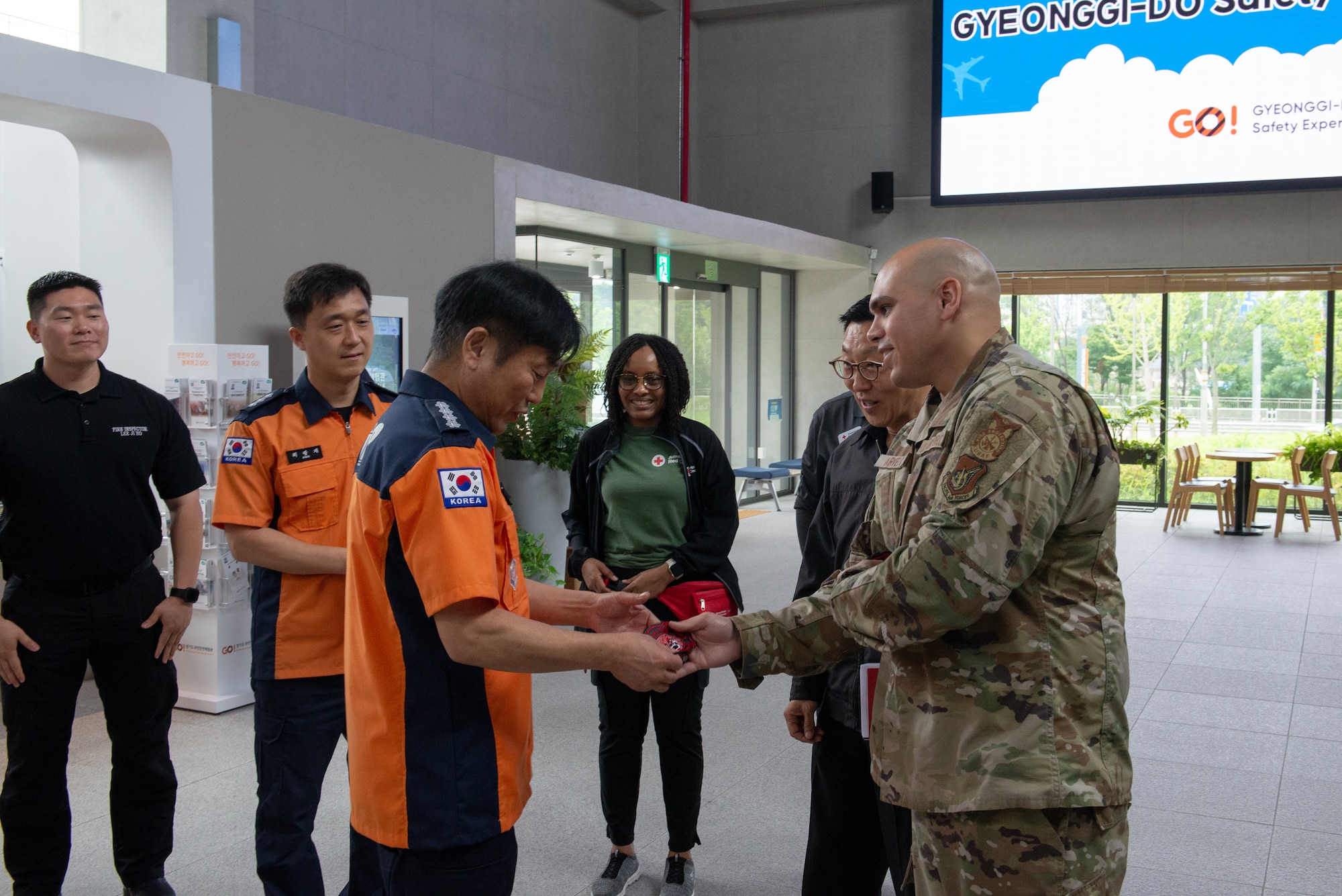 An Airman gifts a unit patch to a Korean safety center employee.