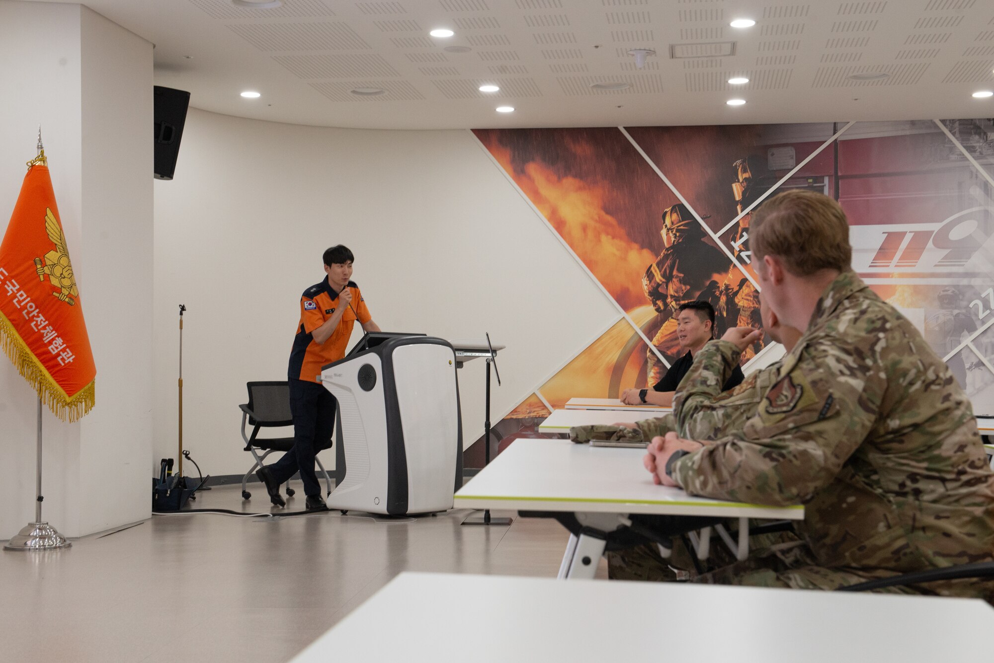 A Korean safety center employee briefs Airmen on the facility and tour details.