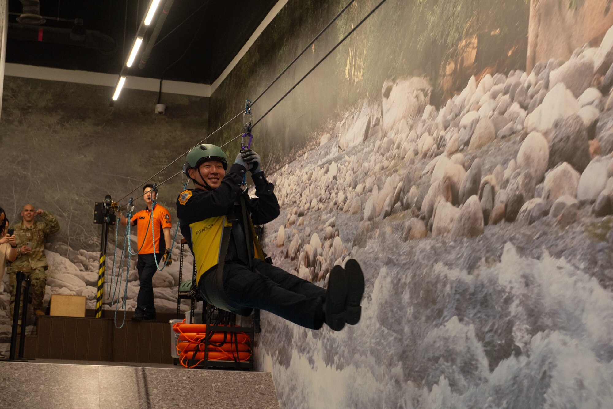 An Osan Air Base fire inspector crosses a simulated flooded river during a safety center tour.