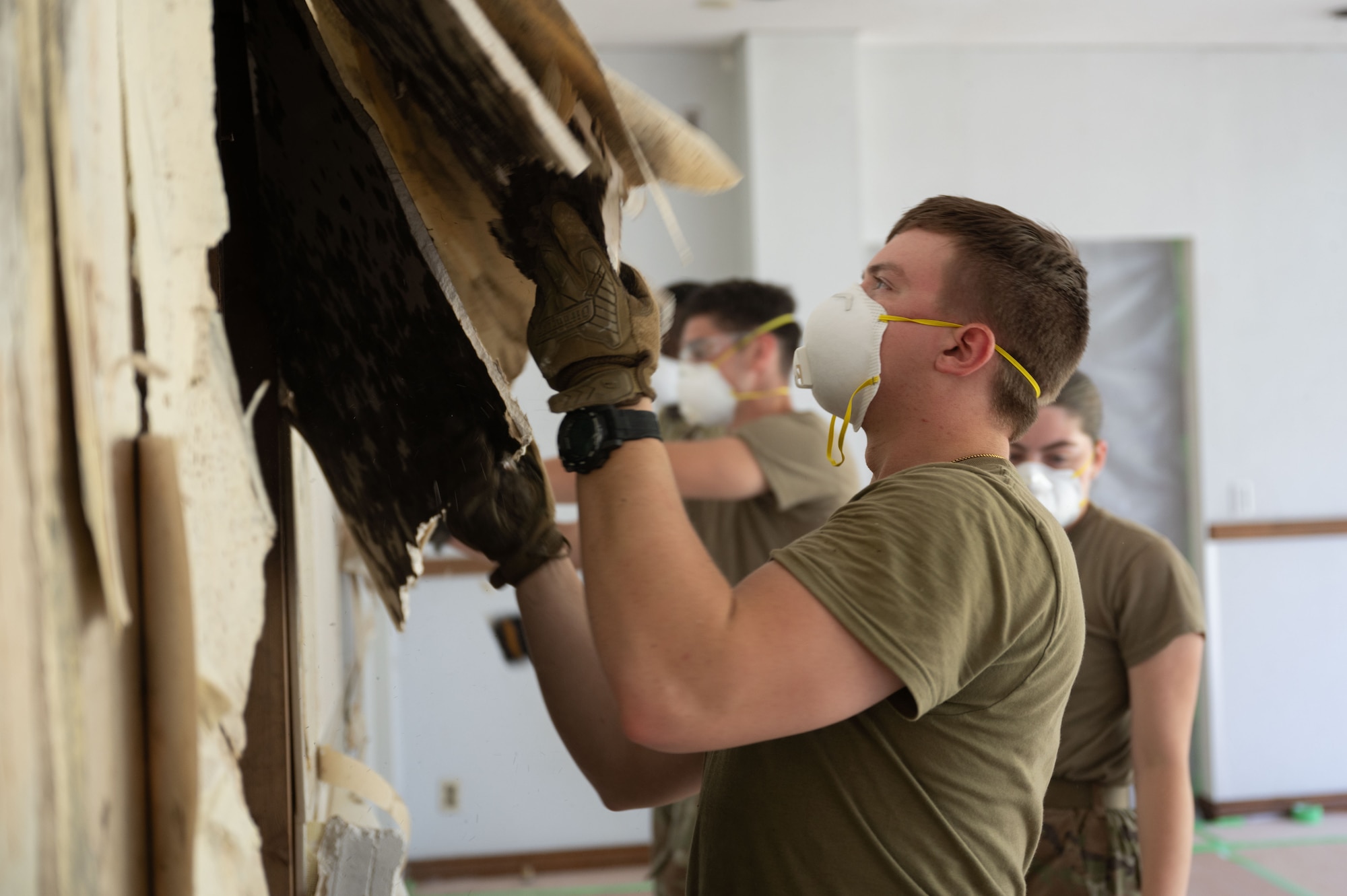 Airman lifts dry wall.