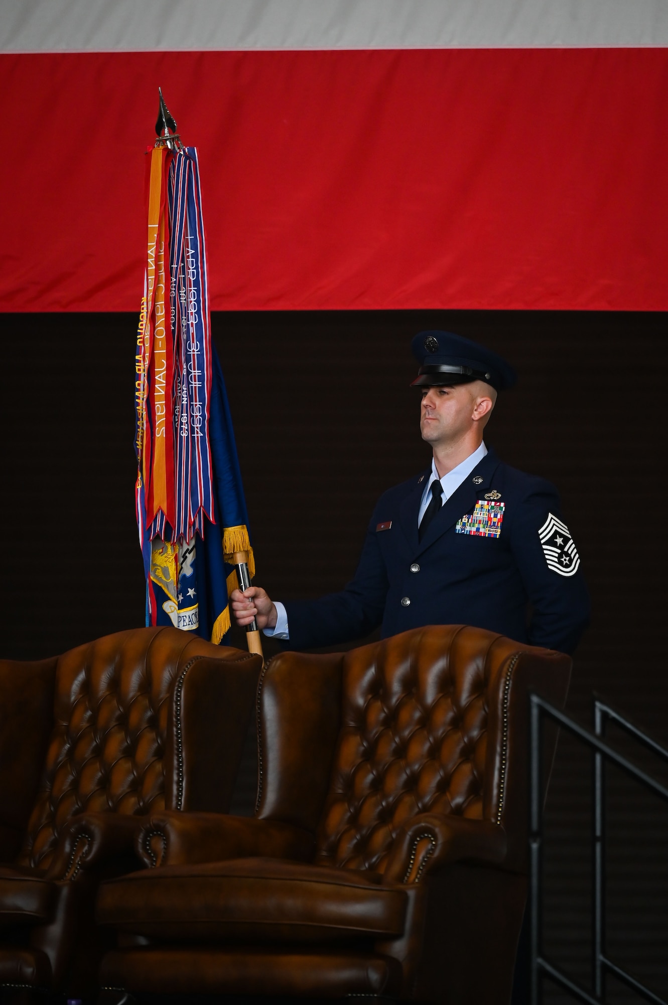 U.S. Air Force Chief Master Sgt. James Wall, 100th Air Refueling Wing incoming command chief, holds the guidon during the 100th ARW change of command ceremony at Royal Air Force Mildenhall, England, July 22, 2025.