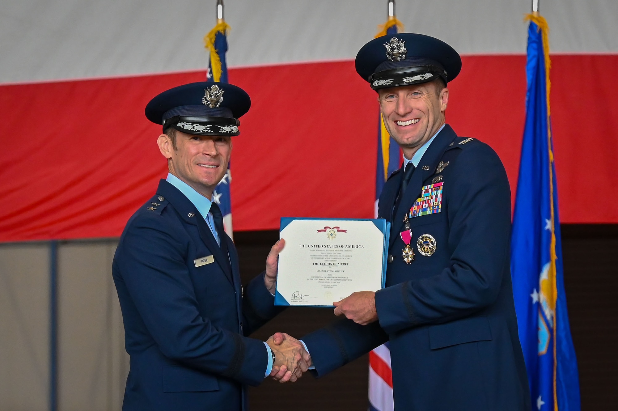 U.S. Air Force Col. Ryan Garlow, 100th Air Refueling Wing outgoing commander, receives the Legion of Merit medal from Maj. Gen. Paul Moga, Third Air Force commander, during the 100th Air Refueling Wing change of command ceremony at Royal Air Force Mildenhall, England, July 22, 2025.