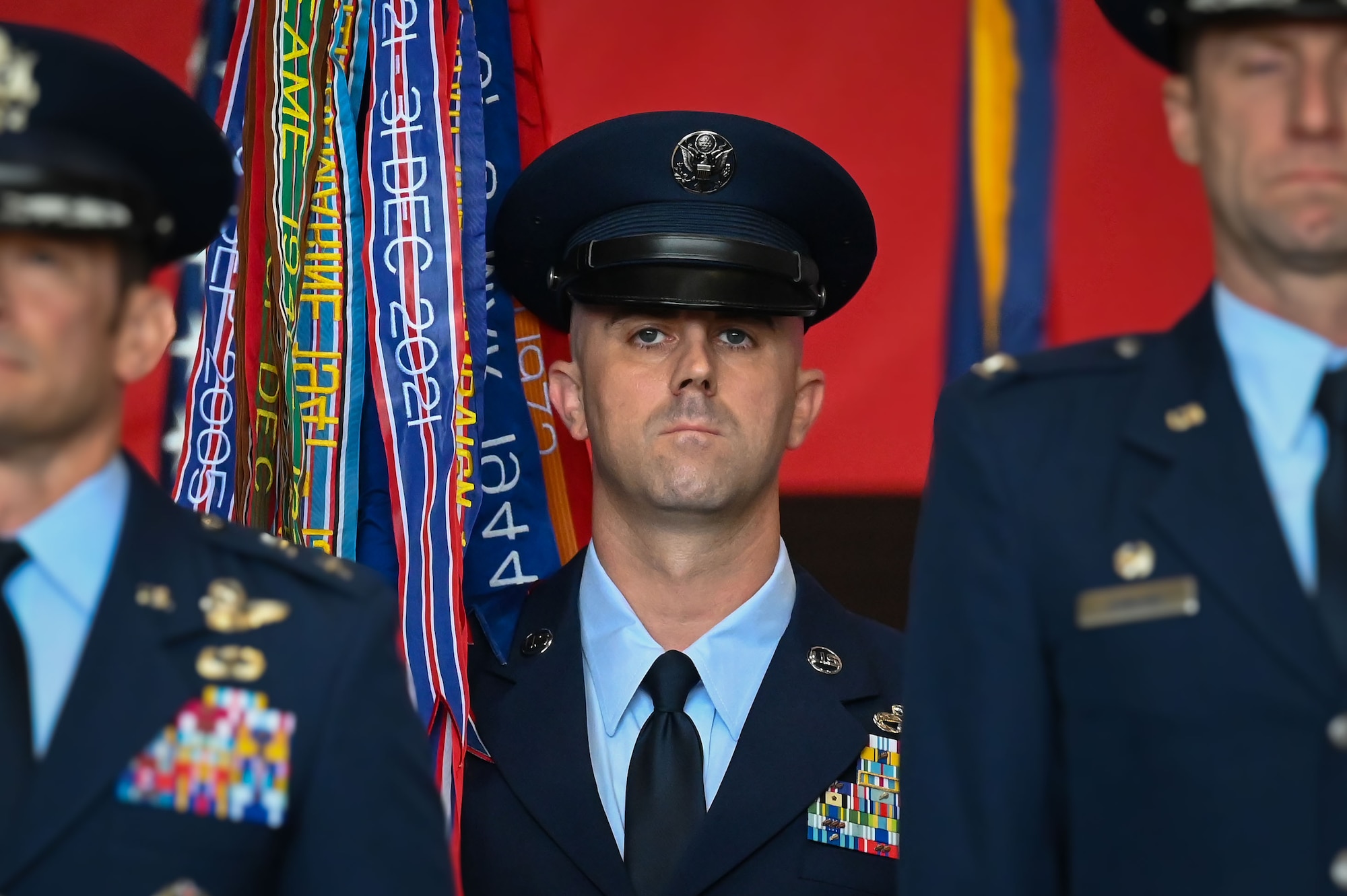 U.S. Air Force Chief Master Sgt. James Wall, 100th Air Refueling Wing incoming command chief, holds the guidon during the 100th ARW change of command ceremony at Royal Air Force Mildenhall, England, July 22, 2025.