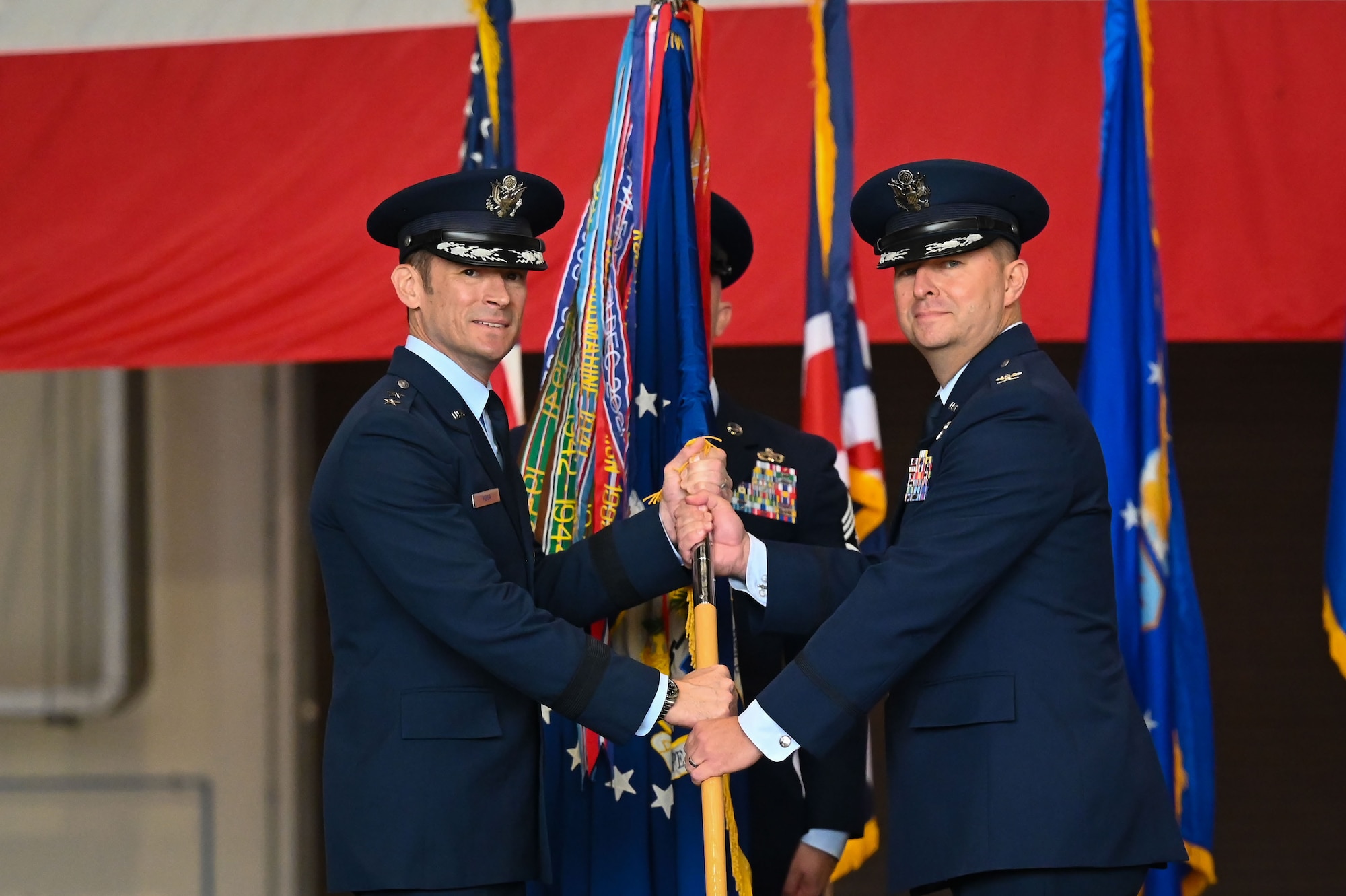 U.S. Air Force Col. Steven Byrum, right, 100th Air Refueling Wing incoming commander, receives the guidon from Maj. Gen. Paul Moga, Third Air Force commander, during the 100th Air Refueling Wing change of command ceremony at RAF Mildenhall, England, July 22, 2025.