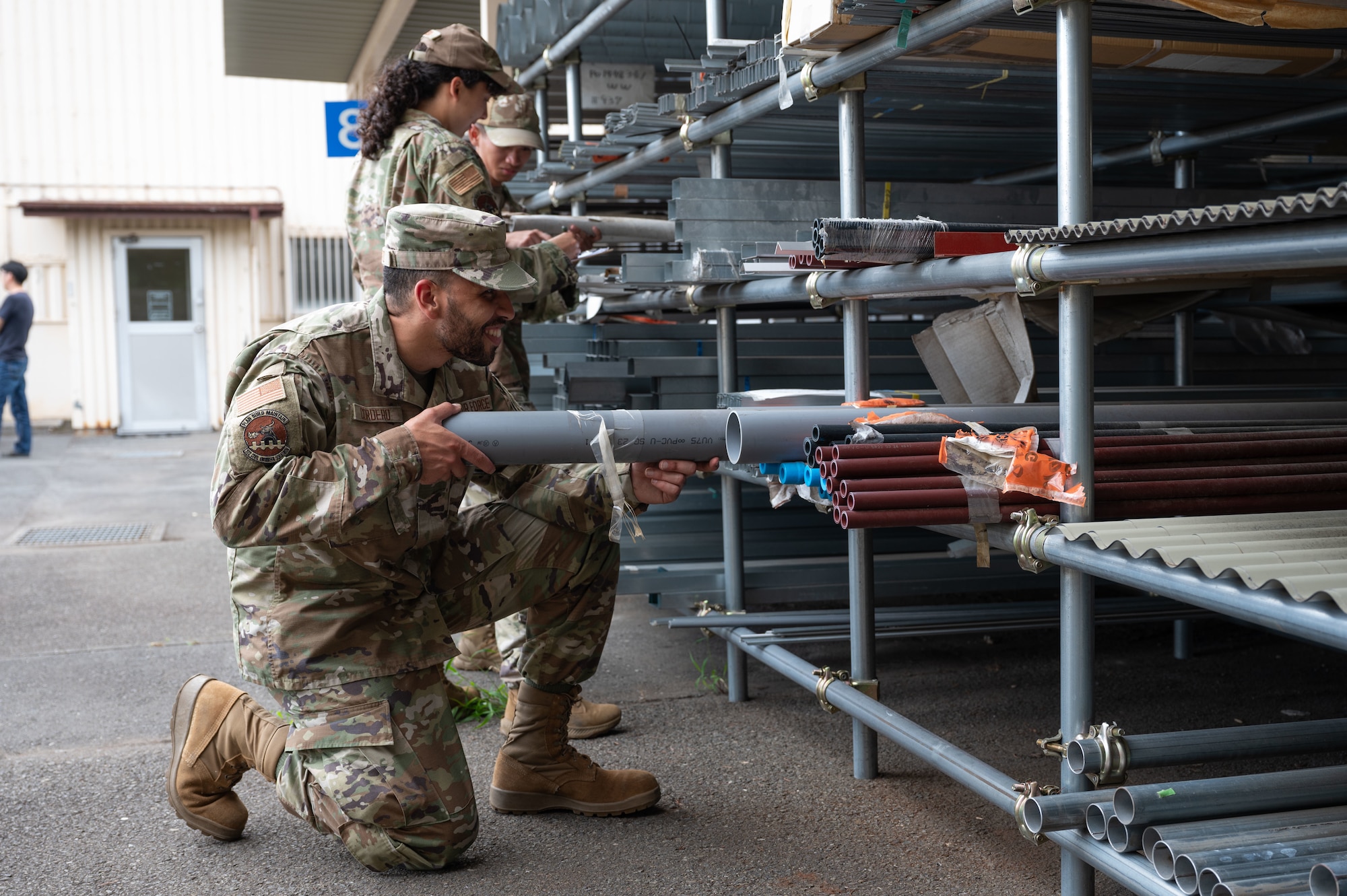 Airmen sort pipes.