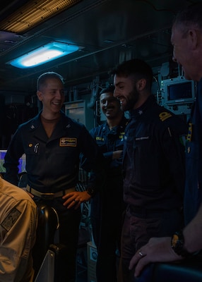 Destroyer Squadron Two Commodore, Capt. Mark Lawrence, left, speaks with Italian Navy Lt. Gabriel Petri, second from the right, a liaison officer from ITS Spartaco Schergat (F598), and other members of the DESRON-2 staff while in USS Gerald R. Ford's (CVN 78) Surface Undersea Combat Center, July 23, 2025. DESRON-2, a part of Carrier Strike Group Twelve, is currently deployed in the U.S. 6th Fleet area of operations to support the warfighting effectiveness, lethality and readiness of U.S. Naval Forces Europe-Africa, and defend U.S., Allied and partner interests in the region. (U.S. Navy photo by Mass Communication Specialist 2nd Class Mariano Lopez)