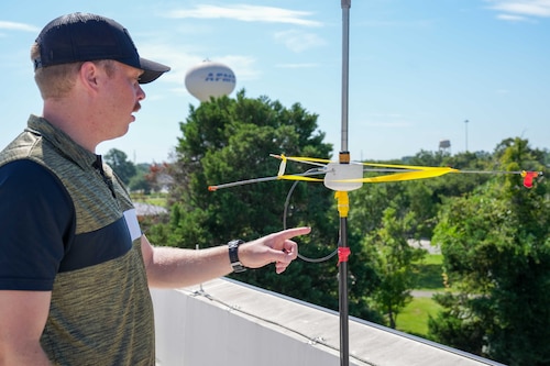 a man points to tape on a rooftop antenna
