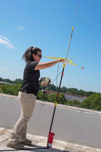 a woman adjusts a rooftop antenna