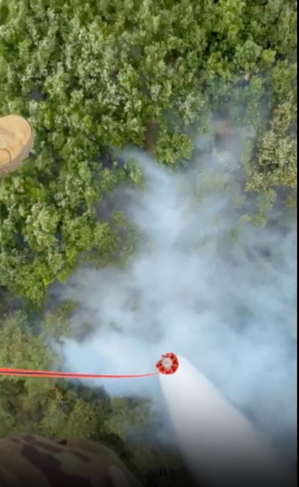 Task Force Aviation of Kentucky National Guard, assigned to the 256th IBCT and KFOR RC-E drops water over a wildfire threatening the Devic Monastery in Kosovo, July 8, 2025. Crews worked 19 hours to suppress the fire using helcopter water buckets.