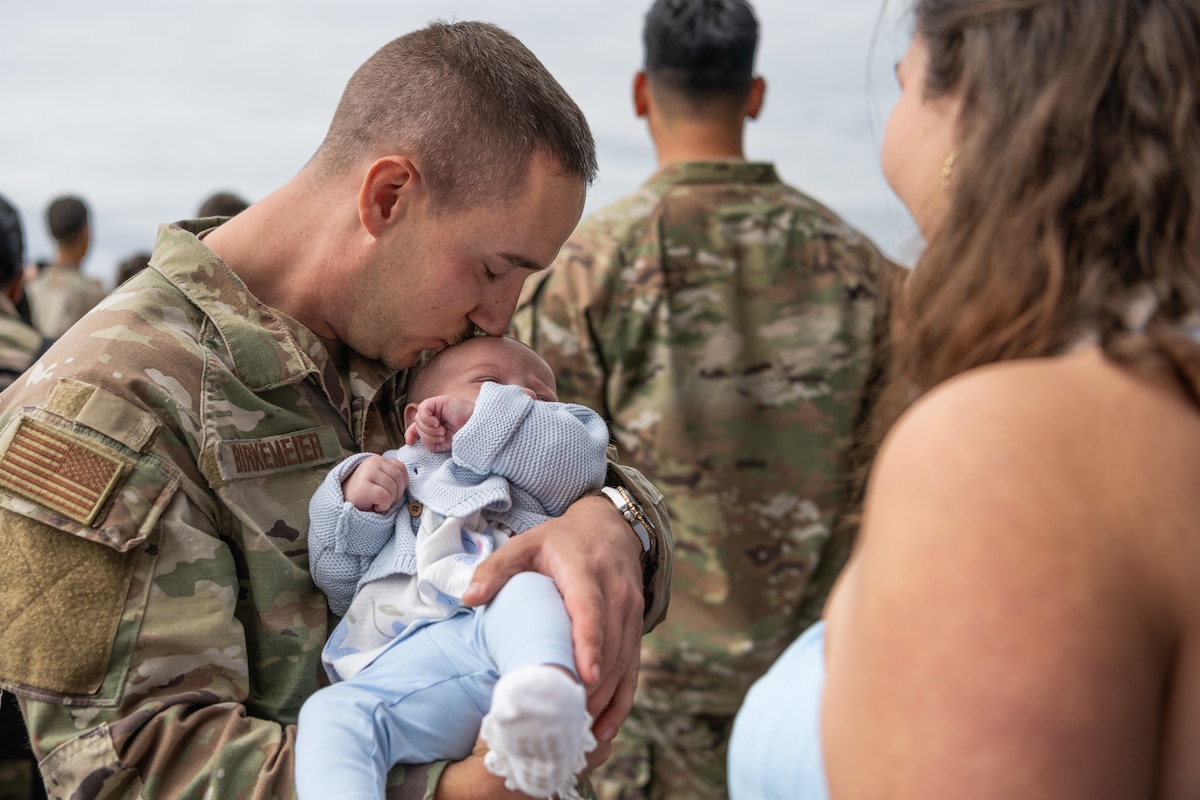 An Airman kisses their baby