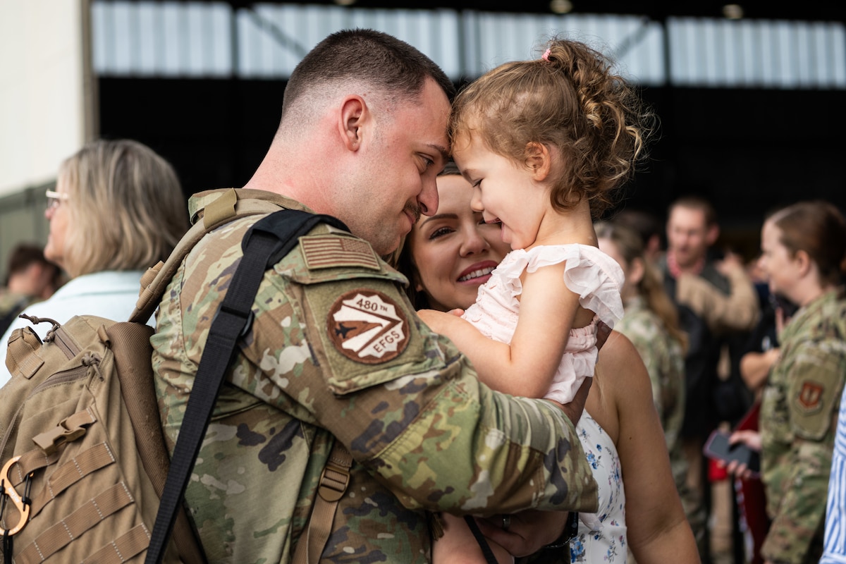 An Airman holds their child