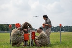 Members of the 102nd Civil Engineer Squadron's (CES) electrical systems shop and 374th CES electrical systems shop work together to enable safe replacement of a damaged airfield sequence flashing light on Yokota Air Base, Japan, July 3, 2025.