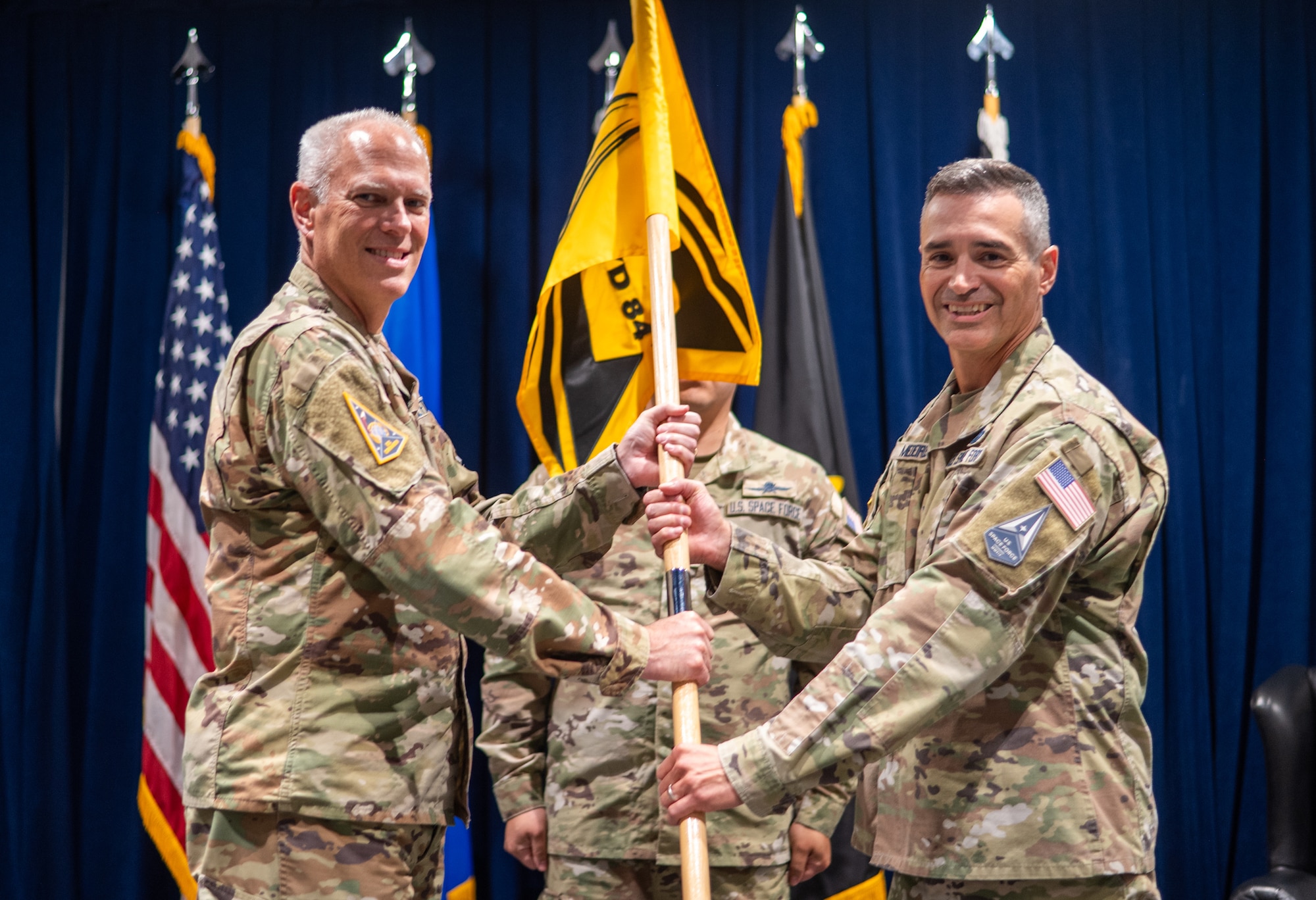 Lt. Gen. Philip A. Garrant, SSC commander passes the SYD 84 guidon to Col. Stevie Medeiros, commander, System Delta 84, Space-Based Missile Warning and Tracking, activating the first of two System Deltas in an Activation Ceremony at the Space Systems Command’s headquarters at Los Angeles Air Force Base, Jul. 10, 2025. [U.S. Space Force Photo by: Van Ha]