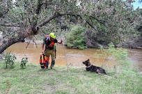 Matej Bartosik, a search and rescue dog handler with the Czech Republic's emergency response team, CZERT, works alongside his search-and-rescue dog, Bart, during flood response operations near Sisterdale, Texas, on July 18, 2025.