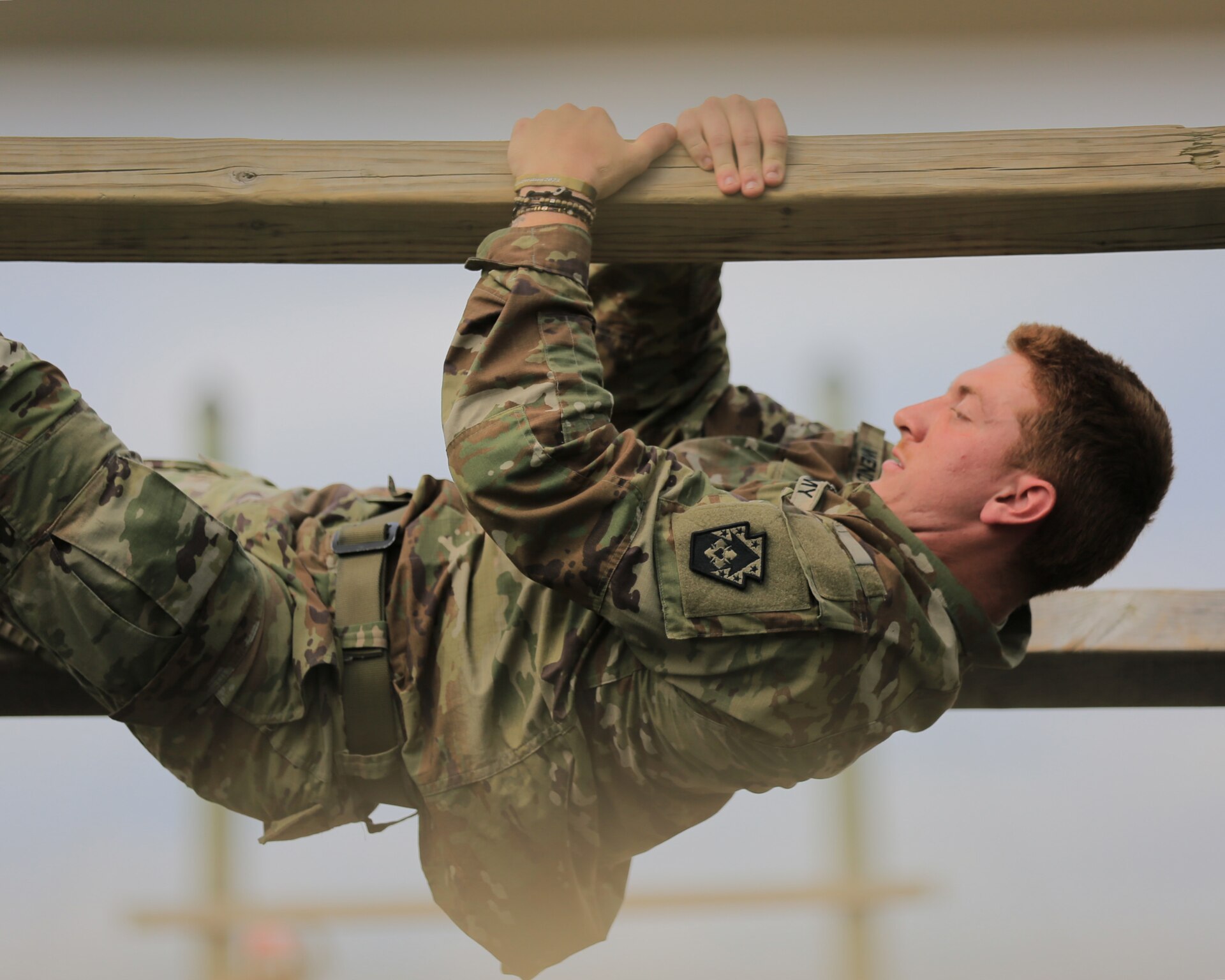 A U.S. Soldier with the 213th Regional Support Group, Pennsylvania National Guard, scales an obstacle on the confidence course at Fort Indiantown Gap, Pennsylvania, July 22, 2025