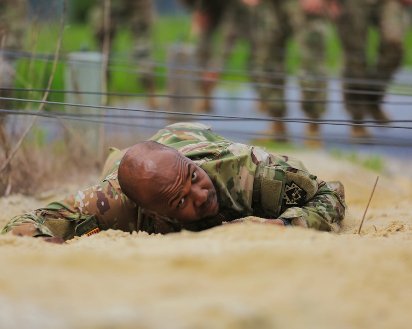 A U.S. Soldier with the 213th Regional Support Group, Pennsylvania National Guard, scales an obstacle on the confidence course at Fort Indiantown Gap, Pennsylvania, July 22, 2025.