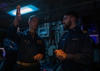 Destroyer Squadron Two Commodore, Capt. Mark Lawrence, left, speaks with Italian Navy Lt. Gabriel Petri, second from the right, a liaison officer from ITS Spartaco Schergat (F598), and other members of the DESRON-2 staff while in USS Gerald R. Ford's (CVN 78) Surface Undersea Combat Center, July 23, 2025. DESRON-2, a part of Carrier Strike Group Twelve, is currently deployed in the U.S. 6th Fleet area of operations to support the warfighting effectiveness, lethality and readiness of U.S. Naval Forces Europe-Africa, and defend U.S., Allied and partner interests in the region. (U.S. Navy photo by Mass Communication Specialist 2nd Class Mariano Lopez)