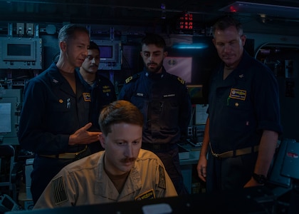 Destroyer Squadron Two Commodore, Capt. Mark Lawrence, left, speaks with Italian Navy Lt. Gabriel Petri, second from the right, a liaison officer from ITS Spartaco Schergat (F598), and other members of the DESRON-2 staff while in USS Gerald R. Ford's (CVN 78) Surface Undersea Combat Center, July 23, 2025. DESRON-2, a part of Carrier Strike Group Twelve, is currently deployed in the U.S. 6th Fleet area of operations to support the warfighting effectiveness, lethality and readiness of U.S. Naval Forces Europe-Africa, and defend U.S., Allied and partner interests in the region. (U.S. Navy photo by Mass Communication Specialist 2nd Class Mariano Lopez)